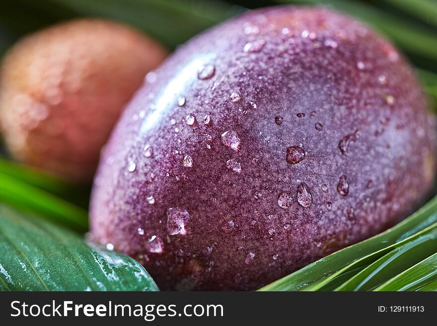 Close-up Of Passion Fruit In A Drops Of Water - Fresh Juicy Exotic Fruit With Tropical Leaf.