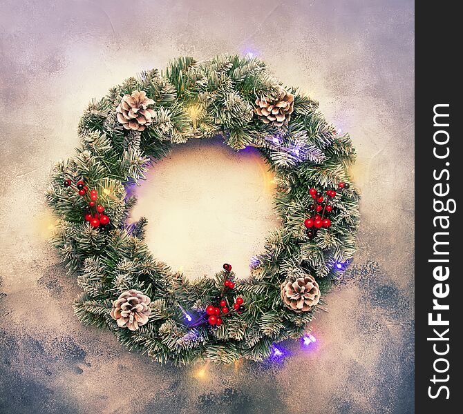 Christmas or New Year frame flat composition with green snow fir branches in wreath, pine cones, golden snowflakes, Christmas balls, red berries on gray background, top view