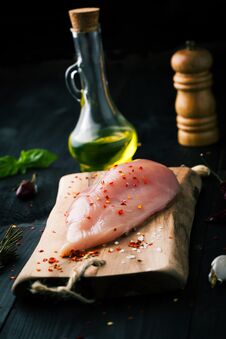 Raw Chicken Fillet With Spices And On A Dark Background Stock Photo