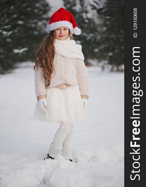 Little happy beautiful girl in winter forest