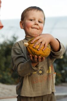 Smiling Boy Standing With Big Yellow Pumpkin In Hands Stock Image