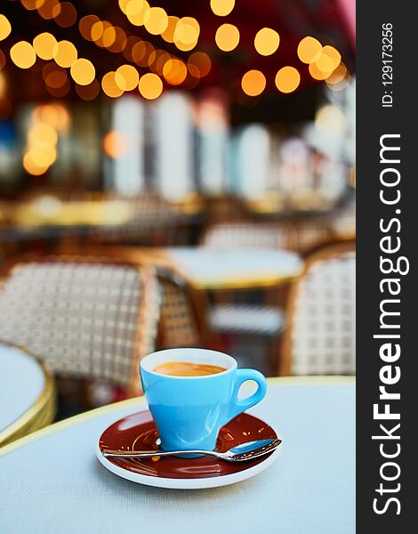 Cup of fresh hot espresso coffee on table of traditional Parisian outdoor cafe in Paris, France