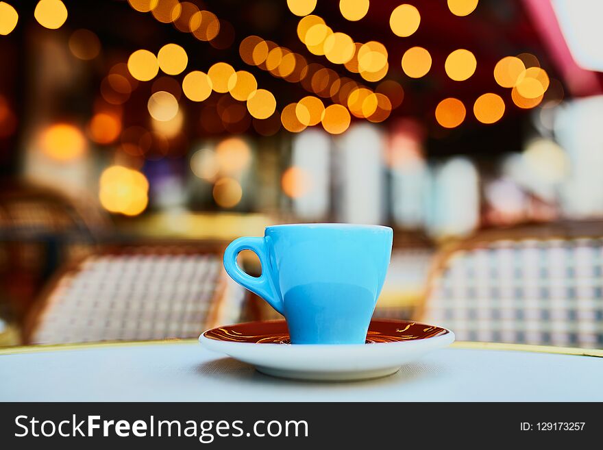 Cup of fresh hot espresso coffee on table of traditional Parisian outdoor cafe in Paris, France