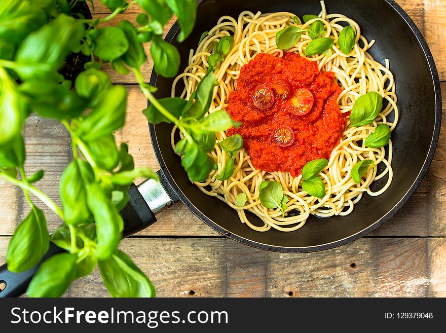 Pasta with herbs, basil and tomato sauce served in a frying pan. Pasta with herbs, basil and tomato sauce served in a frying pan