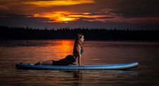Girl Exercising Yoga On Paddleboard In The Sunset On Scenic Lake Velke Darko Stock Photos