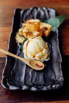 Warabi Mochi Served With A Scoop Of Vanilla Ice Cream That Topping With Caramel Served In Black Plate Royalty Free Stock Photos Warabi Mochi Served With A Scoop Of Vanilla Ice Cream That Topping With Caramel Served In Black Plate Royalty Free Stock Photos