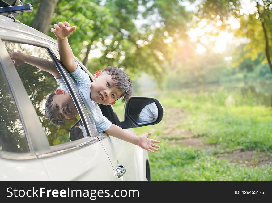 Happy Boy Looks Out From Auto Window And Greets Somebody, Happy Kids Travel By The Car