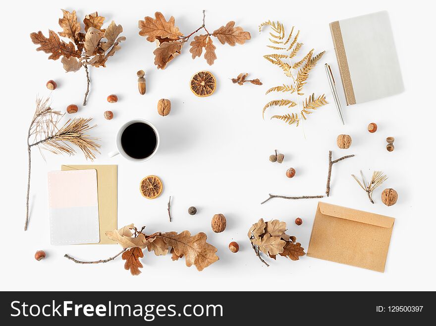 Flat lay fashion autumn feminine home office workspace desk with notepad, envelope, cup coffee, card and dry autumn leaves on white background, top view. Stylish office. Flat lay fashion autumn feminine home office workspace desk with notepad, envelope, cup coffee, card and dry autumn leaves on white background, top view. Stylish office