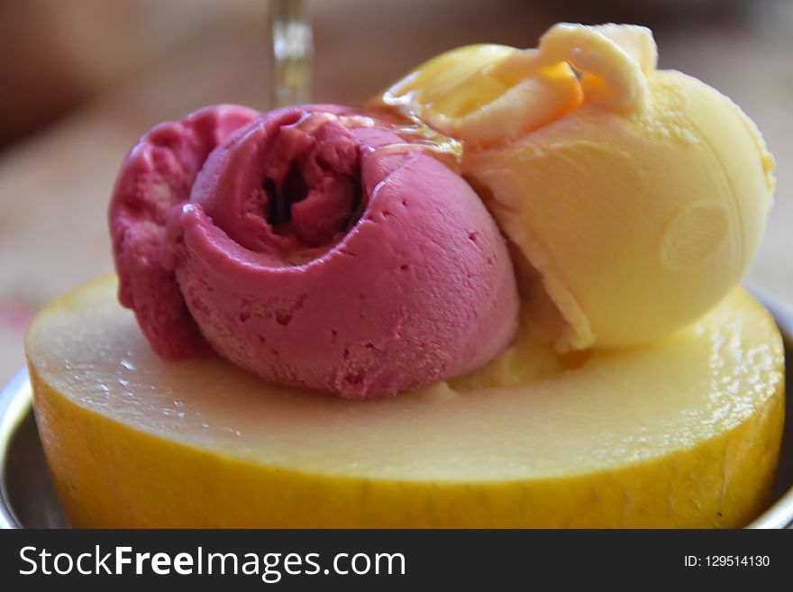 Balls of ice cream and sorbet in multicolor and flavor in a dark ceramic bowl