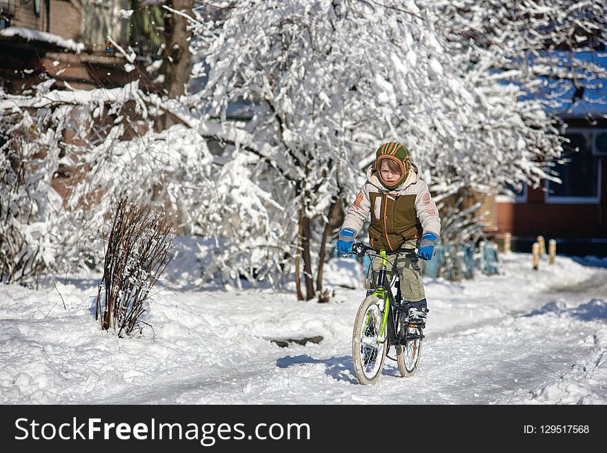 Happy young guy riding bike on fresh snow. Happy young guy riding bike on fresh snow