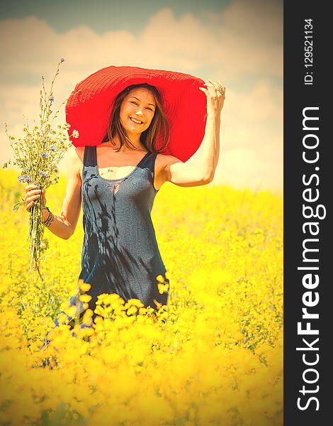 Beautiful woman with a bouquet in a red hat on a sunny day amidst wildflowers. portrait, close-up. style and fashion. retro and vintage. image filter retro style