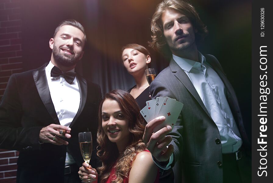 Four people toasting with champagne at roulette in casino