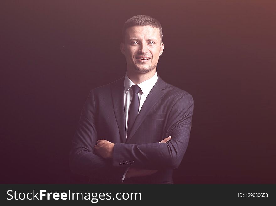 Confident smiling businessman isolated on a dark background. business concept. Confident smiling businessman isolated on a dark background. business concept