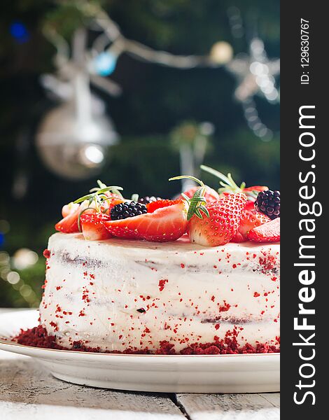 Homemade cake Red Velvet decorated with cream and berries over christmas background