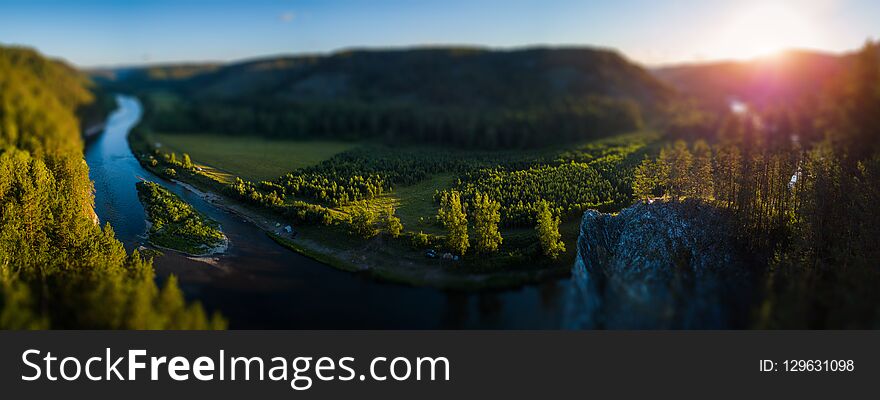 Aerial panorama of the Ural Mountains and the river of Belaya during sunrise. Russia. Tilt shift effect applied