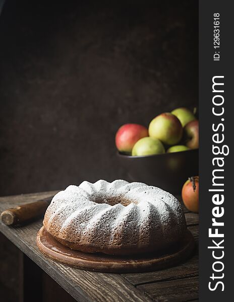 Rustic Style Apple Bundt Cake Sprinkled with Icing Sugar on old wooden table