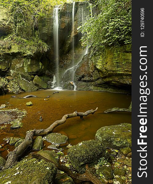 Roughting Linn. Waterfall, Northumberland, England, UK. Surrounded by green summer foliage. and rocks. Roughting Linn. Waterfall, Northumberland, England, UK. Surrounded by green summer foliage. and rocks.