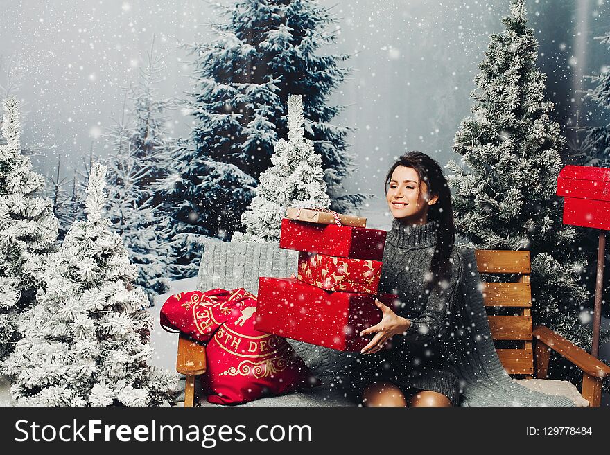 Beautiful woman with pile of Christmas presents.