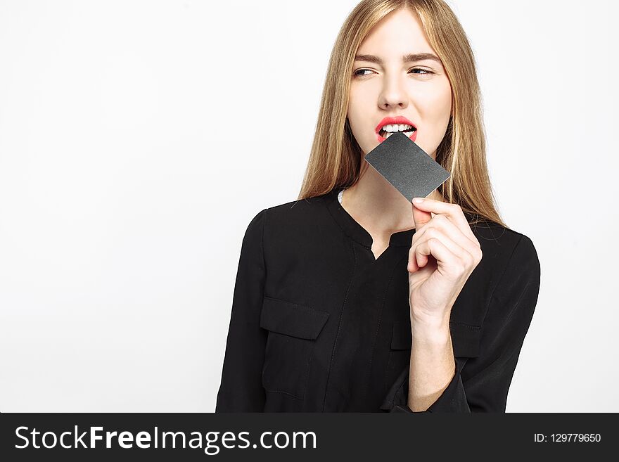 Cheeky girl in black dress and with red lips, holds credit card, white background, black Friday