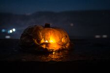 Horror Halloween Concept. Close Up View Of Scary Dead Halloween Pumpkin Glowing At Dark Background. Royalty Free Stock Photo