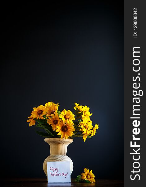 Bouquet of yellow big daisies on a black background