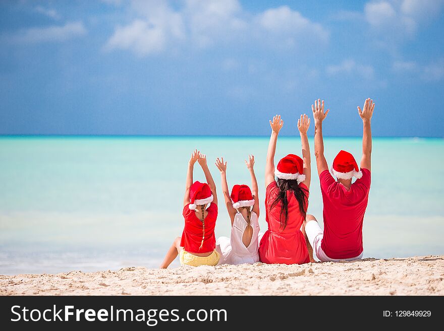 Happy family with two kids in Santa Hat on summer vacation