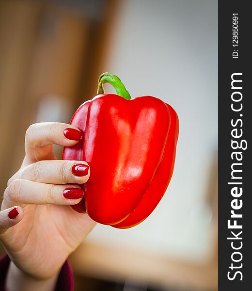 Woman holding red bell pepper