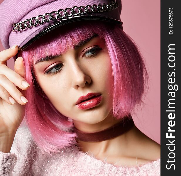 Fashion art photo of young grunge style woman with pink hair in clear modern brown hat cap and choker on pink background. Fashion art photo of young grunge style woman with pink hair in clear modern brown hat cap and choker on pink background