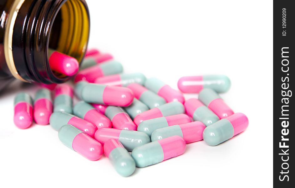 Colorful pills flowing out of bottle