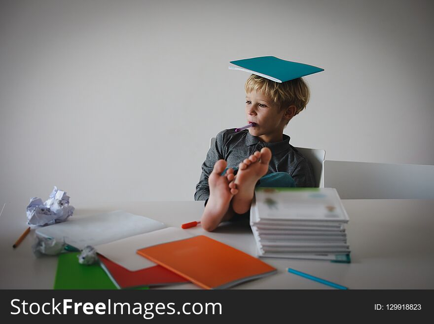 Young boy pretend doing homework relaxed at home, difficult learning