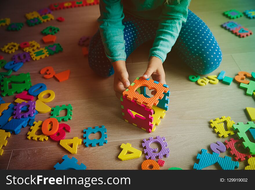 Little girl learning numbers play with puzzle, education