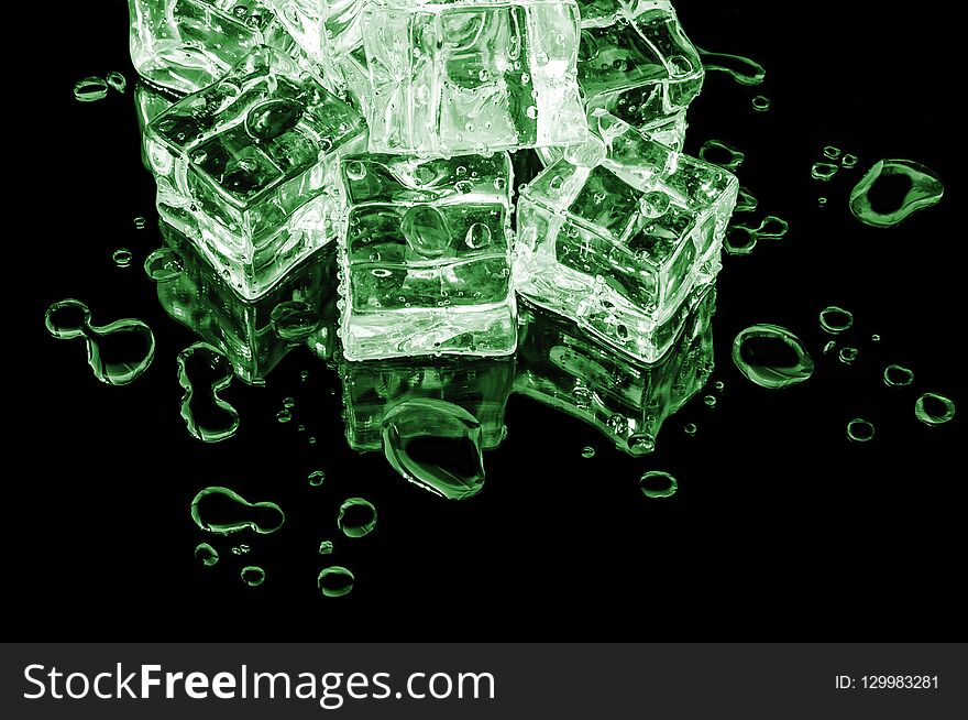 Hill Of Green Ice Cubes On A Black Glass With Water Drops Around.