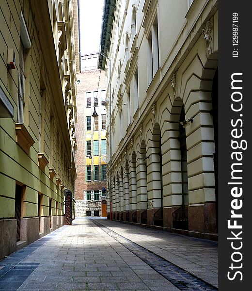 Narrow residential street or allay with classical facades on both sides and stone paving. Narrow residential street or allay with classical facades on both sides and stone paving