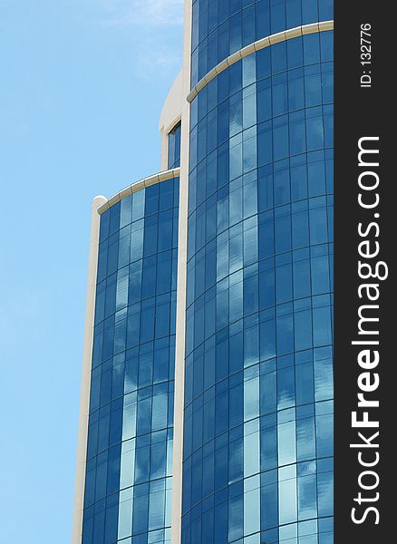 Clouds are reflected in the mirrored windows of this modern structure. Clouds are reflected in the mirrored windows of this modern structure