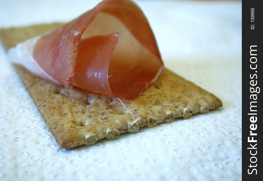 Delicious slice of smoked ham on cracker.