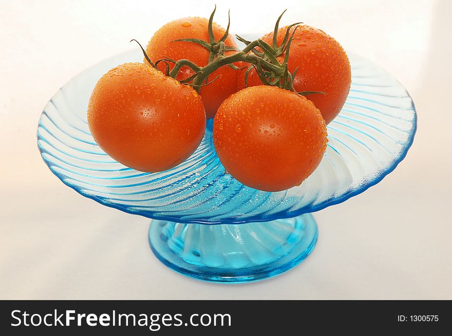 Fresh tomatoes with rain drops in a blue dish. Fresh tomatoes with rain drops in a blue dish