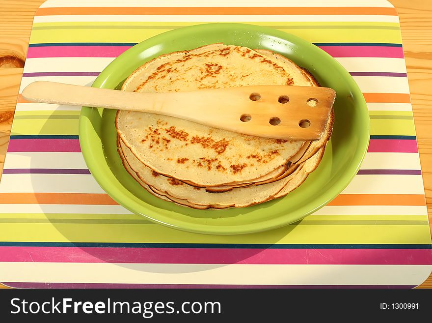 Fresh pancakes on a green plate