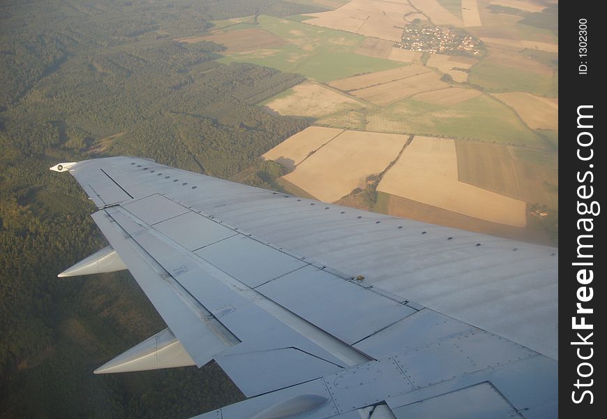View from plane over the wing to landscape underneath. View from plane over the wing to landscape underneath.