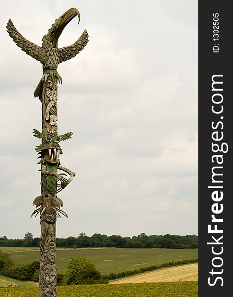 Carved wooden totem pole in green fields