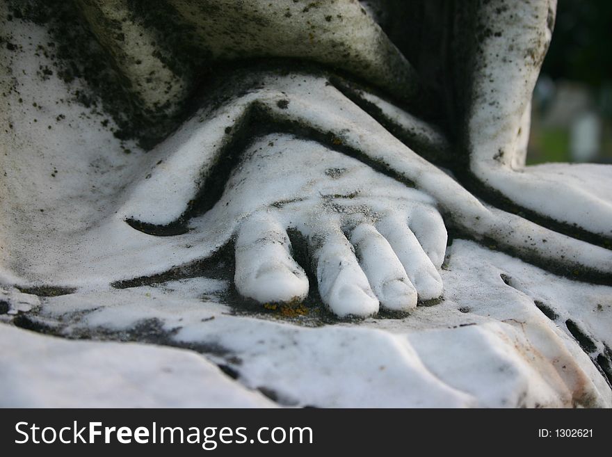 Stone foot of an angel sculpture in a cemetary