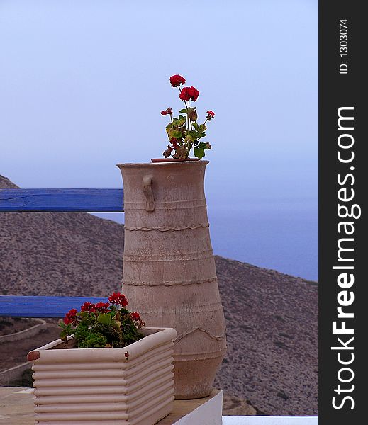 Clay teracotta pots with geranium flowers, in a house overlooking the Aegean, Greece. Clay teracotta pots with geranium flowers, in a house overlooking the Aegean, Greece