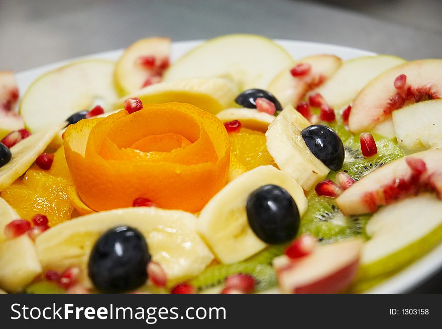 Fresh juicy fruit salad on a plate.