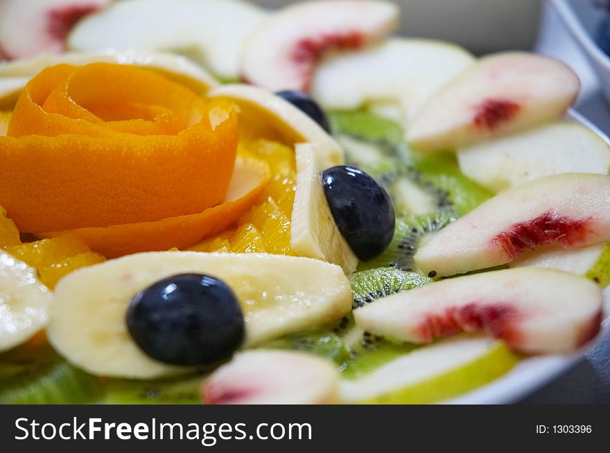 Fresh juicy fruit salad on a plate.