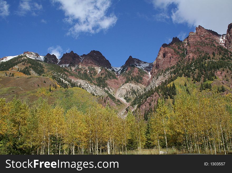 Red mountains with aspen grove in front