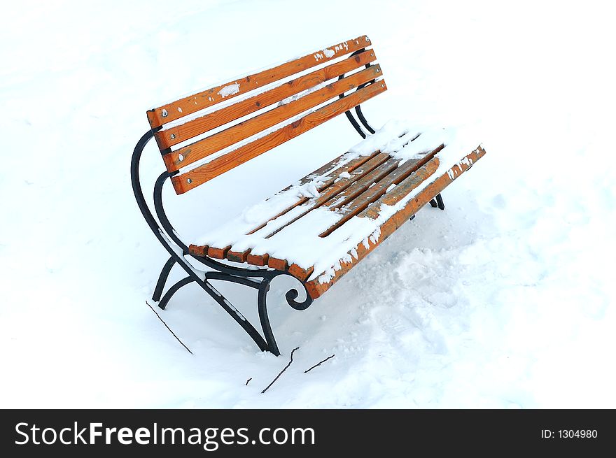 Wooden bench in snowy park