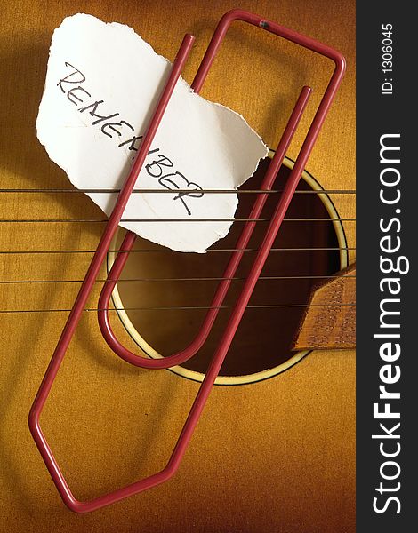 Note and paperclip on a guitar. Note and paperclip on a guitar