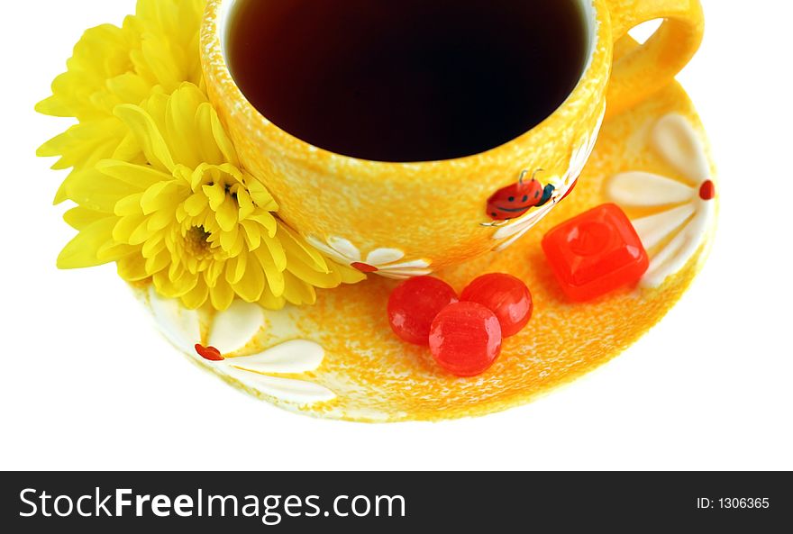 Yellow cup, chrysanthemums and sweets over white. Yellow cup, chrysanthemums and sweets over white