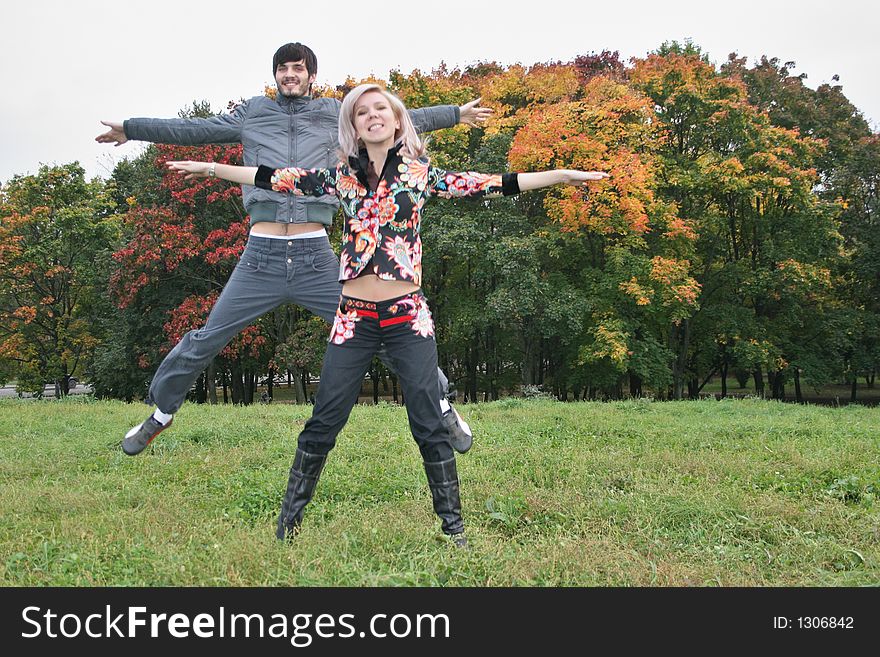 Autumn couple jump in park