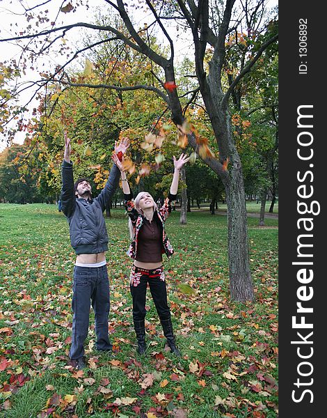 Autumn couple throw maple leaves