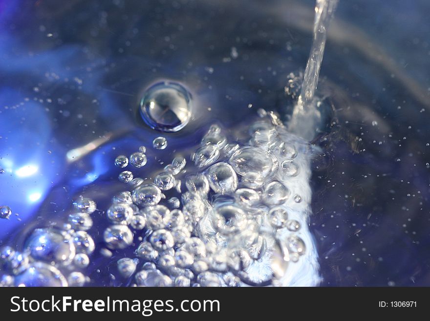 Close-up or Macro of pouring water into a blue bowl.